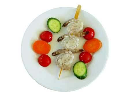 Tiger shrimps with vegetables in a plate isolated on white backgroundの写真素材