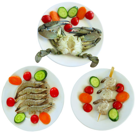 Luxury seafood: Crab, tiger shrimps with vegetables in plates isolated on white backgroundの写真素材
