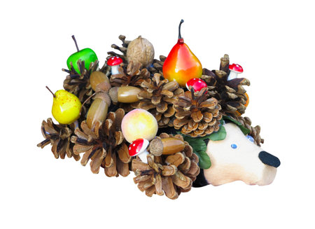 Hedgehog toy made from fir cones with fruits isolated on a white backgroundの写真素材