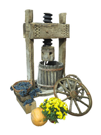 Ancient wooden wine press with cart wheel and basket of grapes isolated over white backgroundの写真素材