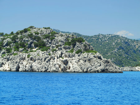 High rock mountains and sea over blue sky backgroundの写真素材