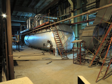 Pipes, steel tubes, steam turbine and equipment at industrial power plant, night sceneの写真素材
