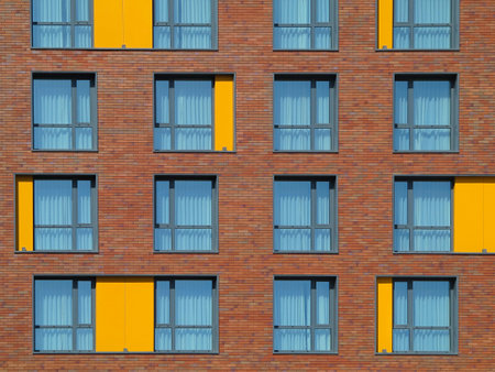 Abstract brown and yellow brick facade with windows backgroundの写真素材