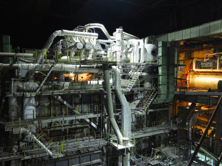 Pipes, steel tubes, steam turbine and equipment at industrial power plant, night sceneの写真素材