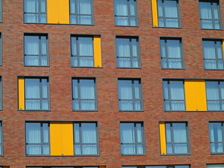 Abstract brown and yellow brick facade with windows backgroundの写真素材