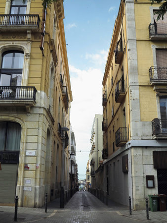 TARRAGONA, SPAIN - 06.07.2022: Street of the old town of the medieval city (World Heritage Site by UNESCO) and its romanesque buildings in a sunny day. CataluÃ±a, Spain.のeditorial素材