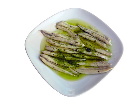 Marinated anchovies in vinegar with olive oil and parsley. Traditional spanish tapa. Isolated on white backgroundの写真素材