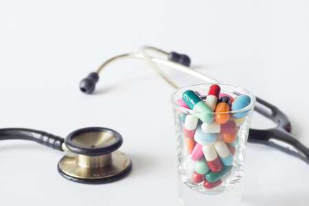 colorful pills in shot glass and Stethoscope on white backgroudの写真素材