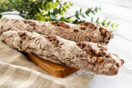 Bread with nuts and raisins on a white wooden backgroundの写真素材