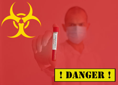 Doctor wearing a medical face mask and gloves, holding a blood test for the Coronavirus COVID-19 outbreak, red background. Coronavirus warning conceptual photo.の写真素材