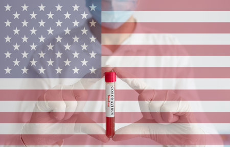 Coronavirus conceptual photo with doctor wearing a medical face mask and gloves, holding a blood test for the COVID-19 pandemic and national flag of United States of America, blurred backgroundの写真素材
