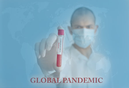 Coronavirus conceptual photo with doctor wearing a medical face mask and gloves, holding a blood test result for the COVID-19 pandemic and blurred world map in the backgroundの写真素材