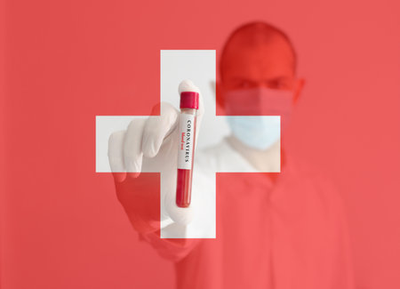 Coronavirus conceptual photo with doctor wearing a medical face mask and gloves, holding a blood test result for the COVID-19 pandemic and national flag of Switzerland, blurred backgroundの写真素材