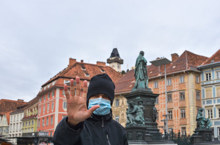 Man on city street wearing a face mask for protection against viruses during coronavirus COVID-19 and flu outbreak in Graz, Styria region, Austria.の写真素材
