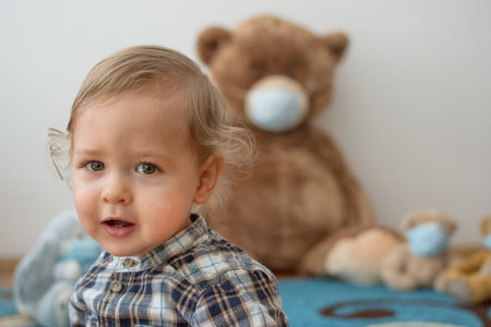 Child playing with his sick teddy bears wearing medical mask against viruses. Role playing, child...