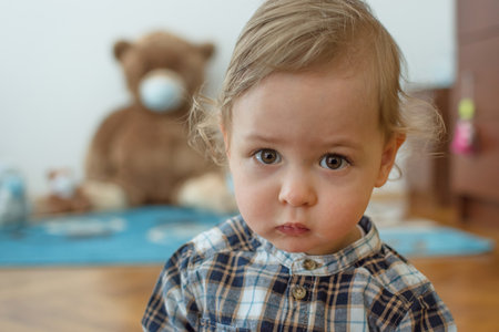 Child playing with his sick teddy bears wearing medical mask against viruses. Role playing, child playing doctor with plush toy. Children and flu, coronavirus illness concept. Selective focusの写真素材