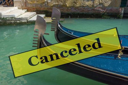 Close up of a two gondolas and the blue water of a Venetian canal, in Venice, Italy. Travel vacations canceled because of pandemic of coronavirus Covid-19, conceptual photo.の写真素材