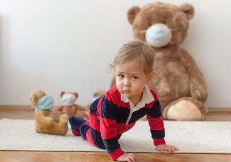 Child playing with his sick teddy bears wearing medical mask against viruses. Role playing, child playing doctor with plush toy. Children and illness concept.の写真素材