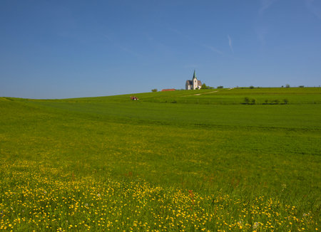 Slovenian countryside in spring with charming little church on a hill, in Sloveniaの写真素材