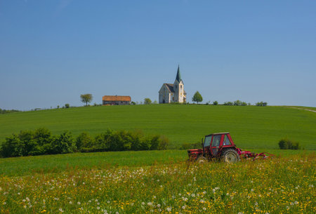 Slovenian countryside in spring with charming little church on a hill, in Sloveniaの写真素材