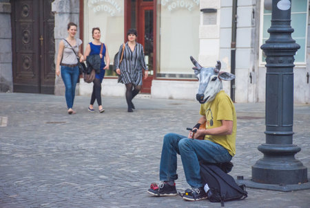 Ljubljana/Slovenia - April 28, 2018: funny street artist singing and wearing a cow head mask