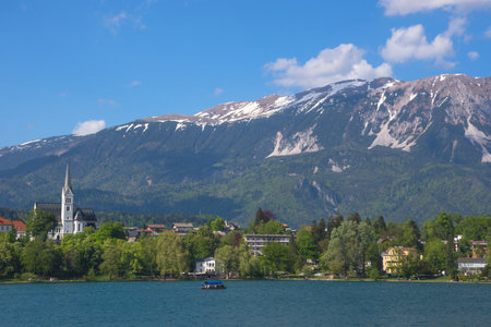 Sunny spring morning at Lake Bled and Julian Alps in the background, famous tourist attraction in...