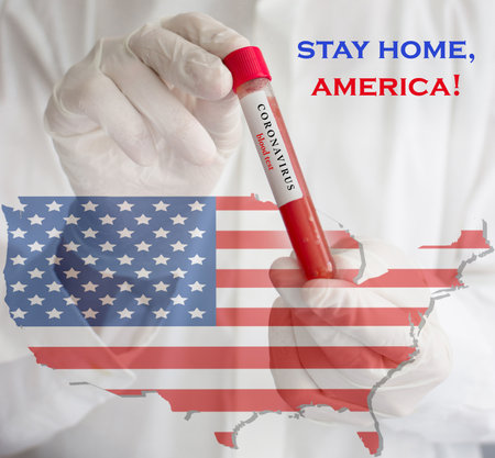 Coronavirus conceptual photo with doctor wearing a medical face mask and gloves, holding a blood test for the COVID-19 pandemic and national flag of United States of America, blurred backgroundの写真素材
