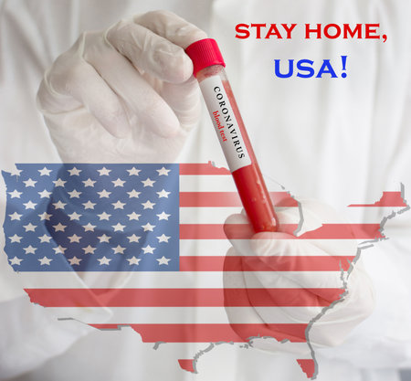 Coronavirus conceptual photo with doctor wearing a medical face mask and gloves, holding a blood test for the COVID-19 pandemic and national flag of United States of America, blurred backgroundの写真素材