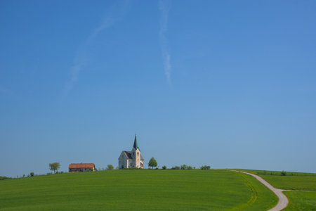 Slovenian countryside in spring with charming little church on a hill, in Sloveniaの写真素材