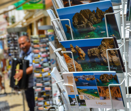 Lagos, Portugal - 15.07.2017. Postcards and a street musician in the background, in the charming historic center of Lagos, in Western Algarve.の写真素材