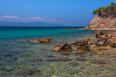 The wild coast of Aegina island with clear and blue waters of Mediterranean sea in the Saronic gulf, Greece.の写真素材