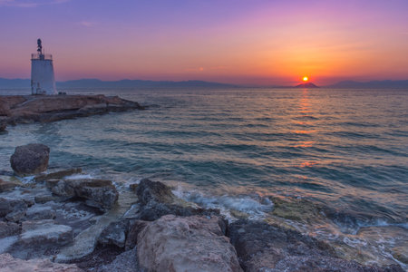 Old small lighthouse of the Aegina island, Saronic gulf, Greece, at sunset.の写真素材