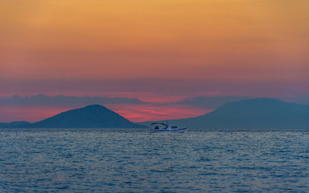 Fishing boat at sunset in the Mediteraneean Sea, Greece.の写真素材