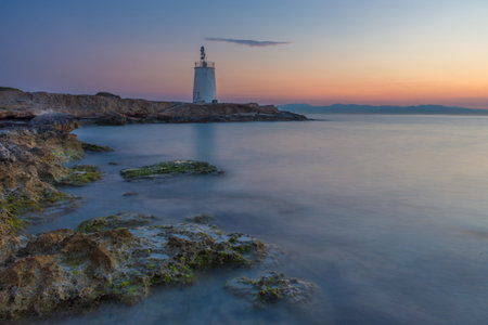 Old small lighthouse of the Aegina island, Saronic gulf, Greece, at sunset.の写真素材