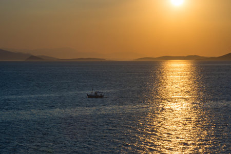Fishermen boat at sunset in the Mediterranean Sea, near Aegina island, Saronic gulf, Greece.の写真素材