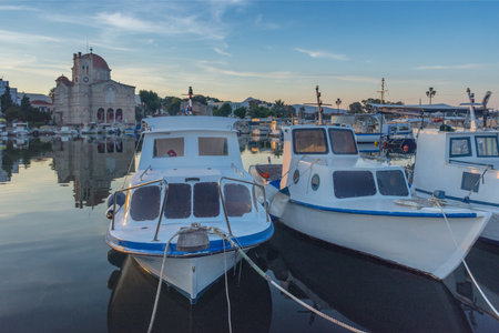 Port of Aegina town with yachts and fishermen boats docked in Aegina island, Saronic gulf, Greece, at sunrise.の写真素材