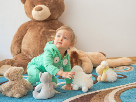 Cute child having fun playing with his teddy bears and plush toys, at homeの写真素材