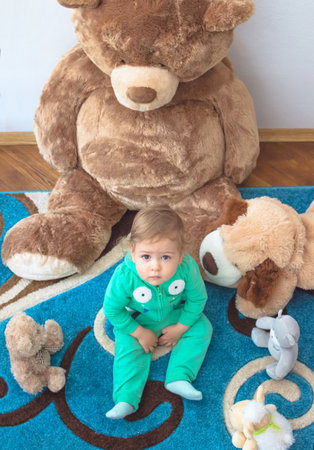 Cute child having fun playing with his teddy bears and plush toys, at home. Top viewの写真素材