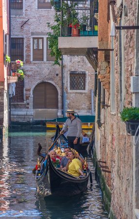 Venice, Italy - April 20, 2019: Venetian canal with gondolas and historic houses, in a beautiful sunny day.のeditorial素材