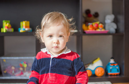 Cute little baby boy portrait with colorful toys in the backgroundの写真素材