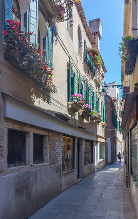 Narrow street with historic houses in Venice, Italy, in a beautiful sunny day.の写真素材
