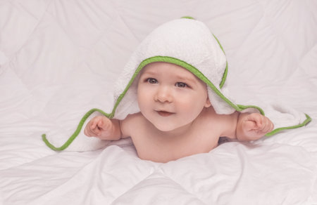 Sweet little baby boy portrait with towel on his head, on white backgroundの写真素材