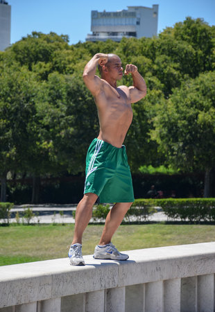 Lisbon, Portugal-20 august 2018. Young man straining his muscles in the Eduardo VII park and gardensのeditorial素材