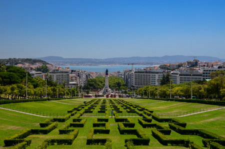 View of the labyrinth of Eduardo VII park and gardens, the largest park in the center of Lisbon, prolonging the main avenue (Avenida da Liberdade) and Tagus river in the background, in Portugal.の写真素材