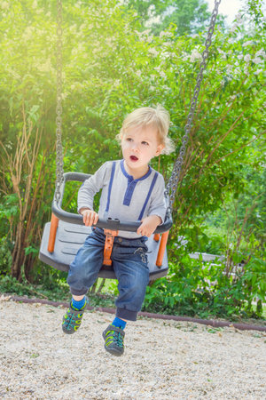 Cute little child having fun inside a wooden house in the park. Beautiful summer sunny day in children playgroundの写真素材