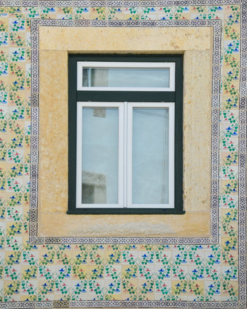 Typical portuguese window with ornamental tiles called "azulejos", made with colored ceramic tiles, in Lisbon, Portugalの写真素材