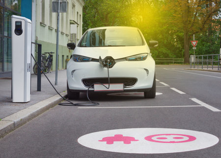 Modern electric car plugged in charging on the street station. New energy vehicles, environment friendly alternative energy for carsの写真素材