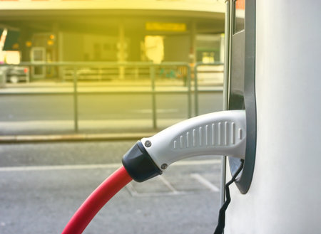 Modern electric car plugged in charging on the street station. New energy vehicles, environment friendly alternative energy for carsの写真素材