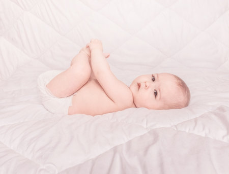 Sweet little baby boy sitting on his tummy, white backgroundの写真素材