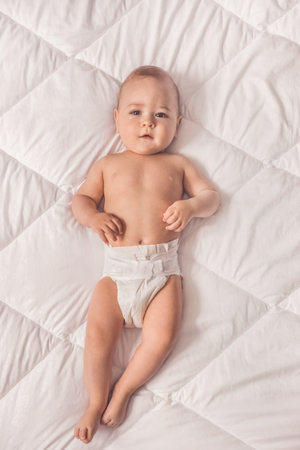 Sweet little baby boy sitting on his tummy, white backgroundの写真素材